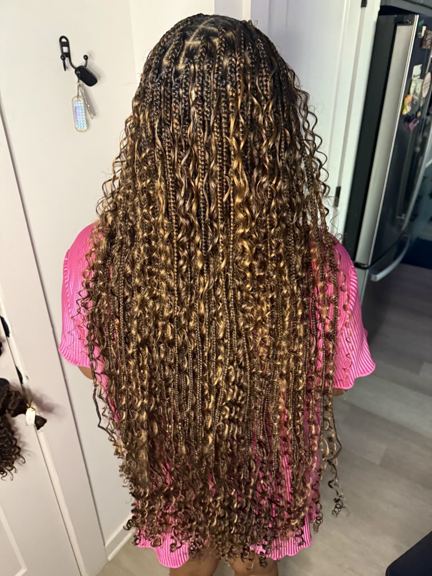 Honey blonde boho braids past the waist, seen from behind