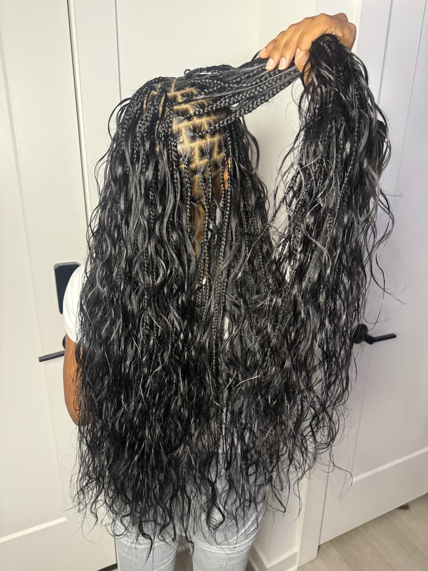 Waist-length boho knotless braids held up to show the full length